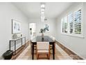 Formal dining room featuring wainscoting, a modern chandelier, and a large window with shutters at 1662 Crestview Ln, Erie, CO 80516