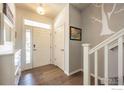 Inviting foyer with hardwood floors, white trim, and a decorative tree wall decal at 190 Olympia Ave, Longmont, CO 80504