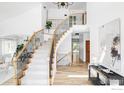 Bright foyer with curved staircase, wooden floors and iron railing for a luxurious feel at 2073 Eisenhower Dr, Louisville, CO 80027