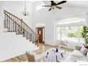 Bright living room boasts a vaulted ceiling and a large window, hardwood floor and a staircase at 2073 Eisenhower Dr, Louisville, CO 80027