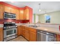 Well-equipped kitchen featuring stainless steel appliances, wood cabinets, and bar seating at 237 Cardinal Way # 202, Longmont, CO 80501