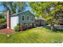 Charming two-story home featuring a well-manicured lawn, mature trees and partial brick facade at 322 W Harper St, Louisville, CO 80027