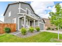 Angle view of charming two-story home showcasing a well-manicured lawn and covered front porch with rocking chairs at 348 Vista Cliff Ct, Castle Rock, CO 80104