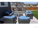 Cozy outdoor living space with a stone fireplace and comfortable seating at 348 Vista Cliff Ct, Castle Rock, CO 80104