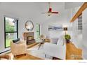 Sunlit living room featuring a cozy fireplace, vaulted ceilings, and large windows at 3880 Telluride Pl, Boulder, CO 80305