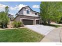 Home exterior featuring a three car garage and large driveway at 3931 Stonegrass Pt, Broomfield, CO 80023