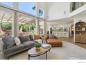 Bright living room with vaulted ceilings, a fireplace, and large windows at 3931 Stonegrass Pt, Broomfield, CO 80023