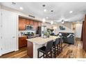 Open kitchen flows into the living area, featuring stainless steel appliances, granite countertops, and an island at 5325 Spalding Pl, Frederick, CO 80504
