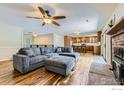 Spacious living room featuring hardwood floors, a brick fireplace, and a large, comfortable sectional sofa at 540 Ithaca Dr, Boulder, CO 80305