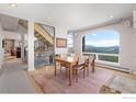 Sunlit dining room with a wooden table and chairs, a large picture window, and scenic views of the mountains at 606 Sugarloaf Mountain Rd, Boulder, CO 80302