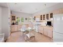 Cozy kitchen featuring a breakfast nook, warm-toned cabinets, tile backsplash, and standard white appliances at 606 Sugarloaf Mountain Rd, Boulder, CO 80302
