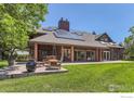 Spacious backyard with patio featuring solar panels, outdoor seating, and well-maintained lawn at 7975 Anchor Dr, Longmont, CO 80504