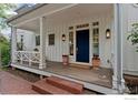 Inviting front porch with a blue door, brick steps, and decorative flower pots at 877 Racquet Ln, Boulder, CO 80303