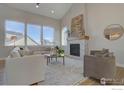 Bright living room with fireplace, large windows, comfortable seating, and hardwood floors at 1030 Turnberry Cir, Louisville, CO 80027
