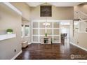 Bright open-concept living room featuring hardwood floors, decorative wall trim and elegant chandelier at 11486 E 119Th Pl, Henderson, CO 80640