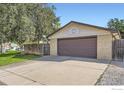 Detached two-car garage with a basketball hoop, a side gate, and a spacious driveway at 11797 Keough Dr, Northglenn, CO 80233