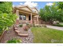 Landscaped front yard with vibrant flowers, a welcoming porch, and a well-maintained lawn at 13266 Teller Lake Way, Broomfield, CO 80020