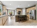 Bright kitchen with stainless steel appliances, stone island with seating, and hardwood floors at 13266 Teller Lake Way, Broomfield, CO 80020