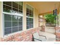 Cozy porch with brick accents, large windows, and a comfortable seating area at 13266 Teller Lake Way, Broomfield, CO 80020