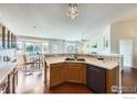 Open kitchen featuring wood cabinets, countertop with tile backsplash, and a dining area at 13586 Raritan St, Westminster, CO 80234