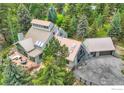 Expansive aerial view of the home's roofline, surrounded by lush greenery and a private drive leading to the garage at 148 Granite Dr, Boulder, CO 80302
