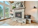 Stone fireplace with wood beam mantel, hearth, and logs sits beneath a large window at 148 Granite Dr, Boulder, CO 80302