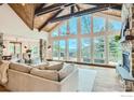 Bright living room features large windows, wood beams, fireplace, and access to a private balcony with views at 148 Granite Dr, Boulder, CO 80302