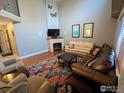 Inviting living room with vaulted ceilings, fireplace, colorful rug, and comfortable seating at 1616 Cedarwood Dr, Longmont, CO 80504