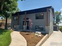 A two-story grey brick house with black trim and manicured landscaping on a sunny day at 1843 Spruce Ave, Longmont, CO 80501