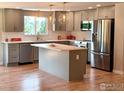 A modern kitchen features stainless steel appliances, a center island, and stylish lighting at 1843 Spruce Ave, Longmont, CO 80501