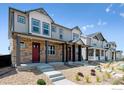 Row of new townhouses featuring stone accents, covered porches, and well-maintained landscaping at 18712 E 99Th Ave, Commerce City, CO 80022