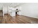 Open-concept kitchen with white cabinets, stainless steel appliances, and a center island at 18712 E 99Th Ave, Commerce City, CO 80022