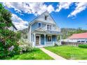 Charming two-story home with a well-manicured lawn, a welcoming porch, and a second-story balcony at 1906 Miner St, Idaho Springs, CO 80452
