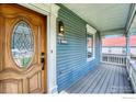 Inviting front porch with a beautiful wood door, blue siding, and vintage exterior lighting at 1906 Miner St, Idaho Springs, CO 80452