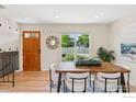 Bright dining area featuring a wooden table, modern chairs, and a stylish mirror at 2016 Strathmore St, Louisville, CO 80027