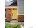 Up close front view of a sunny yellow door and house number at 2016 Strathmore St, Louisville, CO 80027
