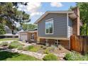 Landscaped front yard and walkway leading to a home with neutral gray siding at 2016 Strathmore St, Louisville, CO 80027