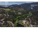 Scenic aerial view of a mountain property surrounded by lush greenery and mature trees, highlighting its tranquil setting at 207 Kelly E Rd, Boulder, CO 80302