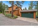 Side view of the home with garage and beautifully landscaped surroundings at 207 Kelly E Rd, Boulder, CO 80302