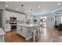 Bright kitchen featuring a large island with seating, stainless steel appliances, and modern lighting at 2332 Tabor St, Berthoud, CO 80513