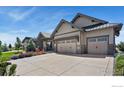Charming exterior view of home featuring a three car garage, driveway, and landscaping at 2737 Heron Lakes Pkwy, Berthoud, CO 80513