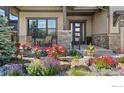 Landscaped front porch features beautiful stone work, ample seating, and elegant design at 2737 Heron Lakes Pkwy, Berthoud, CO 80513