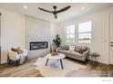 Stylish living room features a cozy fireplace, modern sofa, and natural light from the windows at 2745 Bear Springs Cir, Longmont, CO 80503
