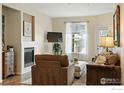 Cozy living room featuring a fireplace, comfortable seating, and a window letting in natural light at 3045 Blue Sky Cir # 105, Erie, CO 80516