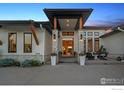 Elegant home entrance with stone pillars, a seating area and an inviting doorway at 3095 Heron Lakes Pkwy, Berthoud, CO 80513