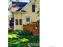 Side view of yellow house showing nice fence and swing set at 310 Judson St, Longmont, CO 80501