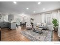 Open concept living space with hardwood floors, neutral decor, and seamless transition to the dining area at 3200 S Grape St, Denver, CO 80222