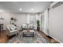 Inviting living room featuring hardwood floors, a comfortable seating arrangement, and a decorative rug at 3200 S Grape St, Denver, CO 80222