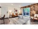 Modern living room showcasing a rustic wood wall, sleek furniture, and an outdoor view through sliding doors at 3250 Oneal Cir # 10, Boulder, CO 80301