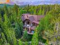 Stunning aerial view of a luxury home surrounded by lush greenery and a manicured lawn at 41 Stillson Placer Ter, Breckenridge, CO 80424